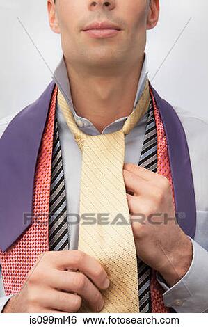 Young man trying on ties View Large Photo Image Stock Photograph - Young man trying on ties. Fotosearch