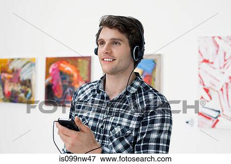 Young man using audio guide in art gallery View Large Photo Image Stock Photo - Young man using audio guide in art gallery. Fotosearch