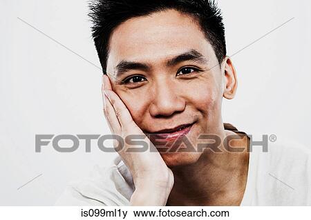 Young man with hand on chin View Large Photo Image Stock Photo - Young man with hand on chin. Fotosearch