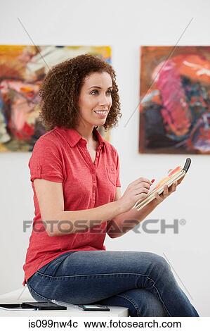 Young woman drawing in sketch pad in art gallery View Large Photo Image Stock Image - Young woman drawing in sketch pad in art gallery. Fotosearch
