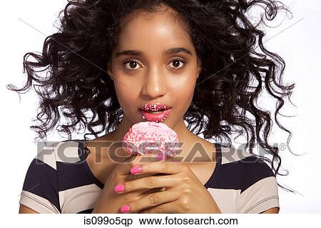 Young woman eating cupcake, studio shot View Large Photo Image Stock Photography - Young woman eating cupcake, studio shot. Fotosearch