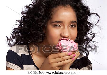 Young woman eating cupcake, studio shot View Large Photo Image Stock Photography - Young woman eating cupcake, studio shot. Fotosearch