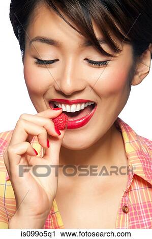 Young woman eating raspberry, studio shot View Large Photo Image Stock Image - Young woman eating raspberry, studio shot. Fotosearch