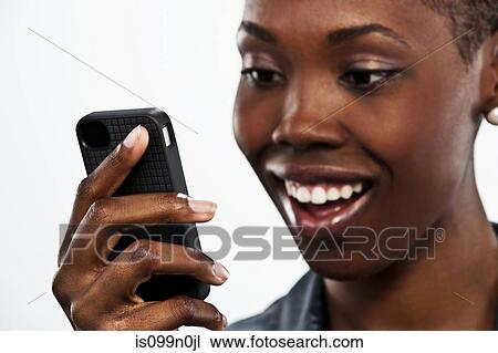 Young woman holding cellphone against white background View Large Photo Image Stock Image - Young woman holding cellphone against white background. Fotosearch
