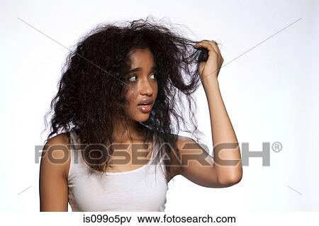 Stock Photo - Young woman holding hair against white background. Fotosearch