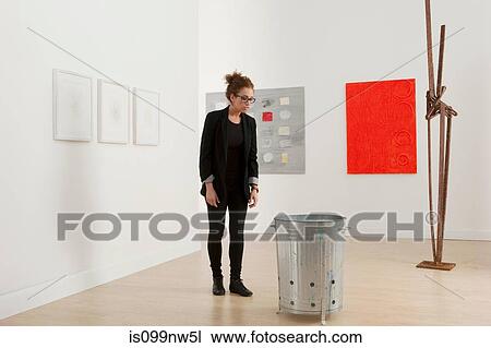 Young woman looking at artwork in gallery View Large Photo Image Stock Image - Young woman looking at artwork in gallery. Fotosearch