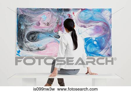 Young woman looking at oil painting in gallery View Large Photo Image Stock Photo - Young woman looking at oil painting in gallery. Fotosearch