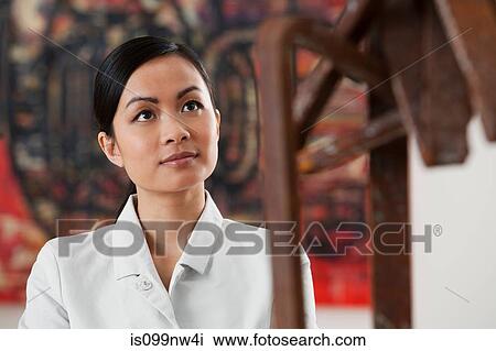Young woman looking at sculpture in art gallery View Large Photo Image Stock Image - Young woman looking at sculpture in art gallery. Fotosearch
