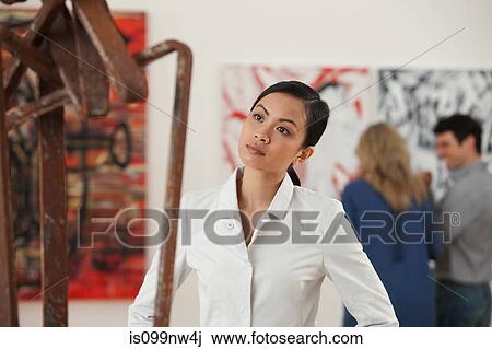 Young woman looking at sculpture in art gallery View Large Photo Image Stock Image - Young woman looking at sculpture in art gallery. Fotosearch