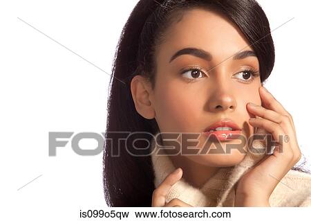 Stock Photo - Young woman looking away in polo neck against white background. Fotosearch