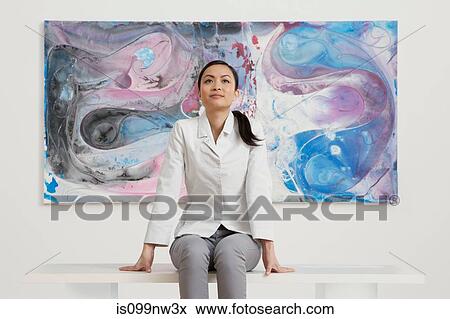 Young woman sitting in front of oil painting in gallery View Large Photo Image Stock Photo - Young woman sitting in front of oil painting in gallery. Fotosearch