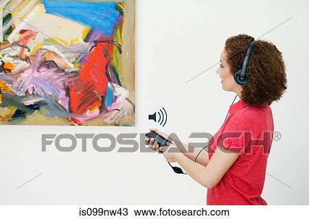 Young woman using audio guide in art gallery View Large Photo Image Stock Image - Young woman using audio guide in art gallery. Fotosearch