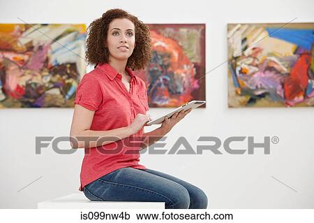 Young woman using digital tablet in art gallery View Large Photo Image Stock Image - Young woman using digital tablet in art gallery. Fotosearch