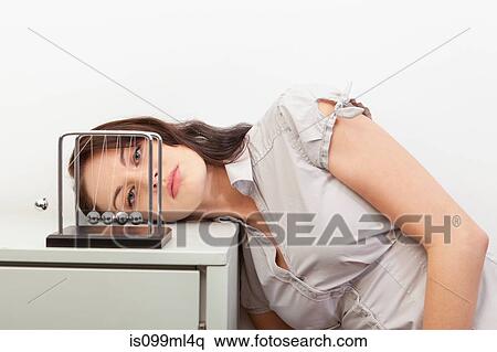 Young woman watching newtons cradle View Large Photo Image Stock Photography - Young woman watching newtons cradle. Fotosearch