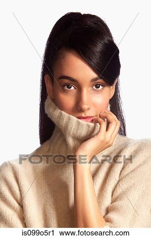 Young woman wearing polo neck against white background View Large Photo Image Stock Image - Young woman wearing polo neck against white background. Fotosearch