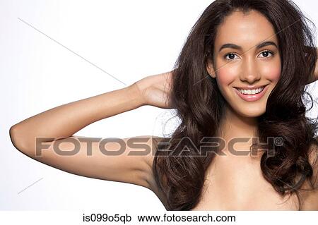 Young woman with hands in hair against white background View Large Photo Image Stock Image - Young woman with hands in hair against white background. Fotosearch