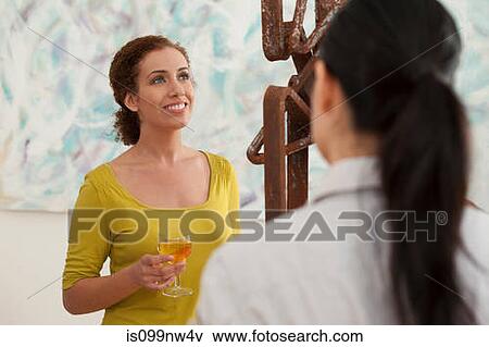 Stock Photo - Young women looking at sculpture in art gallery. Fotosearch