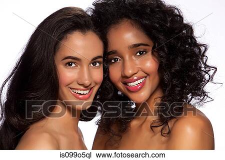 Stock Image - Young women smiling against white background. Fotosearch