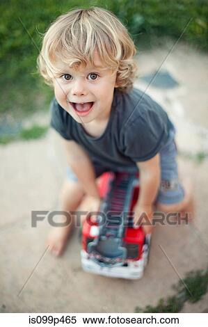 Boy playing with toy fire engine View Large Photo Image Stock Photography - Boy playing with toy fire engine. Fotosearch