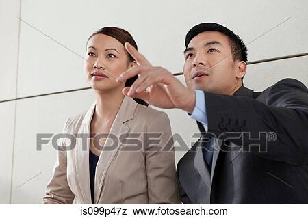 Stock Photo - Business colleagues, man pointing. Fotosearch