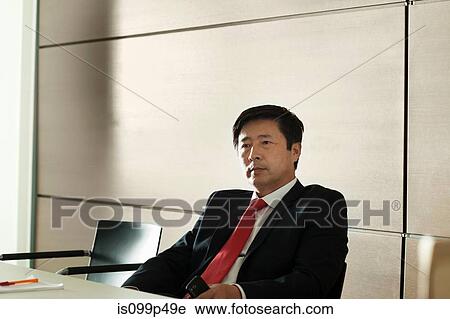 Businessman sitting in meeting room, portrait View Large Photo Image Stock Image - Businessman sitting in meeting room, portrait. Fotosearch