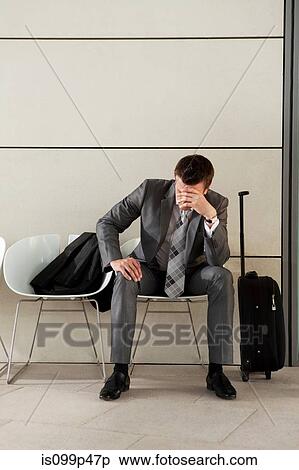 Businessman waiting with luggage and head in hands View Large Photo Image Stock Photography - Businessman waiting with luggage and head in hands. Fotosearch