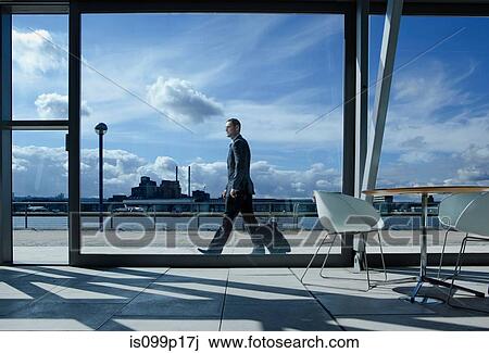 Businessman walking with suitcase outside airport View Large Photo Image Stock Image - Businessman walking with suitcase outside airport. Fotosearch