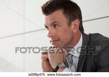 Businessman with hand on chin, portrait View Large Photo Image Stock Image - Businessman with hand on chin, portrait. Fotosearch