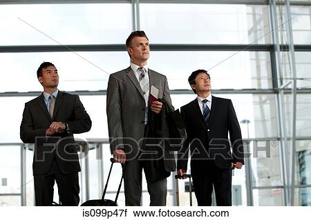 Stock Image - Businessmen arriving at airport. Fotosearch