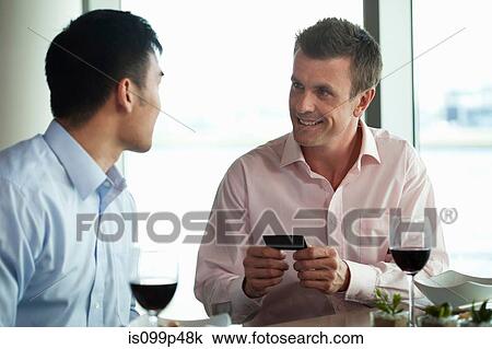 Stock Image - Businessmen exchanging business cards. Fotosearch