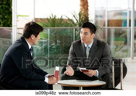 Stock Photo - Businessmen with airline tickets and passport. Fotosearch