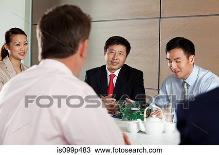 Businesspeople discussing circuit board in meeting View Large Photo Image Stock Image - Businesspeople discussing circuit board in meeting. Fotosearch