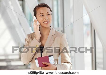 Businesswoman on cell phone with airline ticket and passport View Large Photo Image Stock Image - Businesswoman on cell phone with airline ticket and passport. Fotosearch