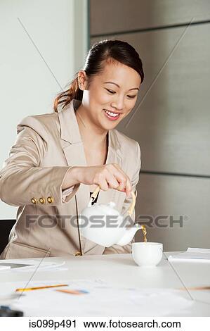 Businesswoman pouring tea View Large Photo Image Stock Image - Businesswoman pouring tea. Fotosearch