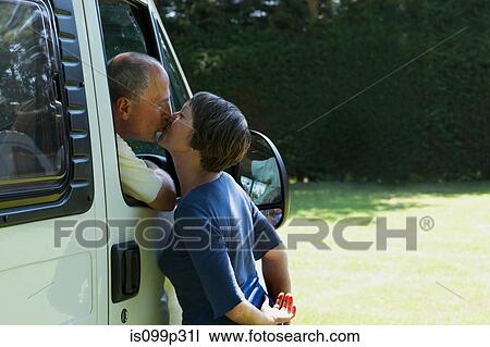 Couple kissing outside campervan View Large Photo Image Stock Image - Couple kissing outside campervan. Fotosearch