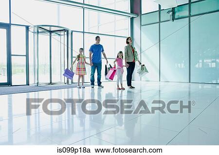 Stock Image - Family in airport with shopping bags. Fotosearch