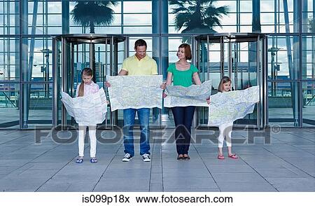 Stock Photo - Family with maps outside airport. Fotosearch