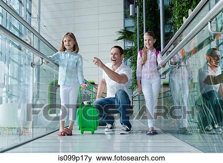 Father and daughters with luggage in airport View Large Photo Image Stock Photo - Father and daughters with luggage in airport. Fotosearch