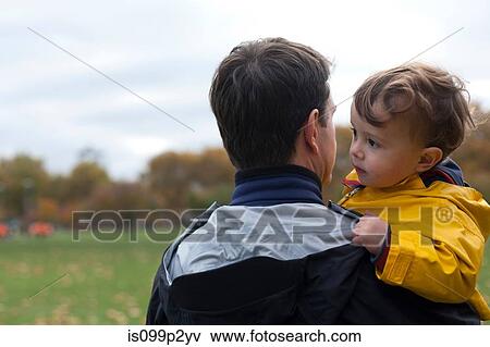 Stock Photo - Father holding young son in park. Fotosearch