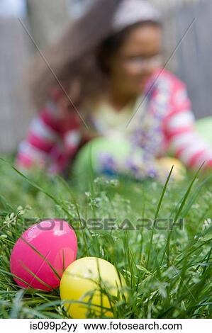 Girl looking for easter eggs in grass View Large Photo Image Stock Photo - Girl looking for easter eggs in grass. Fotosearch