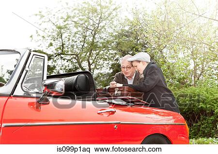 Grandfather and grandson packing vintage car with trunk suitcase View Large Photo Image Stock Photography - Grandfather and grandson packing vintage car with trunk suitcase. Fotosearch