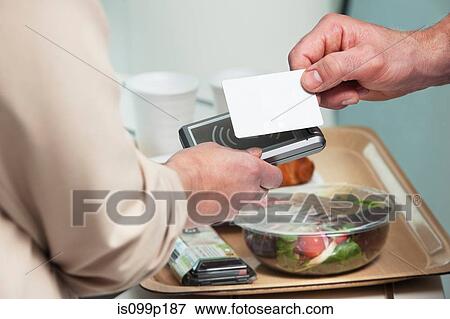 Man using card to buy food View Large Photo Image Stock Photo - Man using card to buy food. Fotosearch