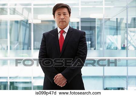 Stock Image - Mature businessman looking at camera, portrait. Fotosearch