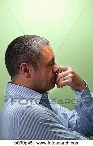 Stock Image - Mature male teacher with hand on chin. Fotosearch