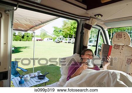 Mature woman reading in camper van View Large Photo Image Stock Photo - Mature woman reading in camper van. Fotosearch