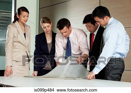 Picture - Multi racial businesspeople discussing blueprint. Fotosearch