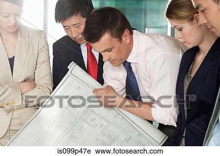 Stock Image - Multi racial businesspeople discussing blueprint. Fotosearch