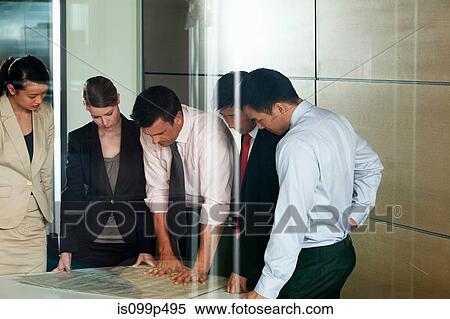 Multi racial businesspeople discussing blueprint View Large Photo Image Stock Photography - Multi racial businesspeople discussing blueprint. Fotosearch