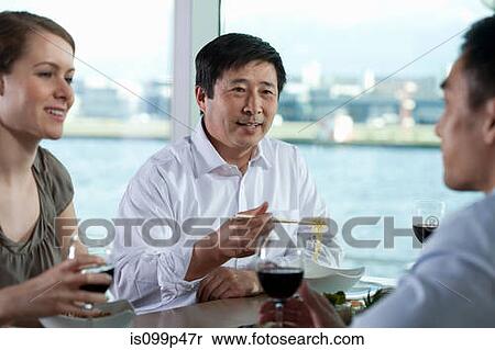 Multi racial businesspeople eating meal View Large Photo Image Stock Photography - Multi racial businesspeople eating meal. Fotosearch