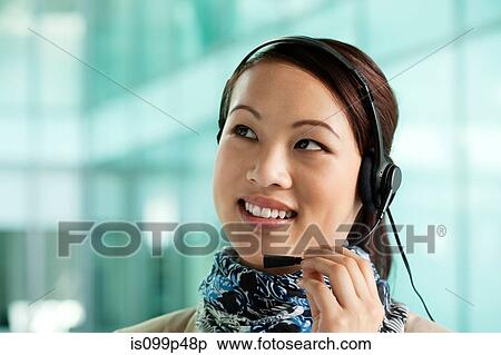 Stock Photography - Office worker wearing headset. Fotosearch